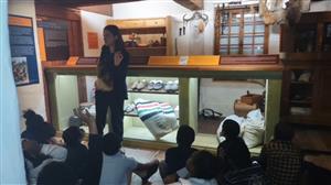 students sitting on the floor looking at a piece of art